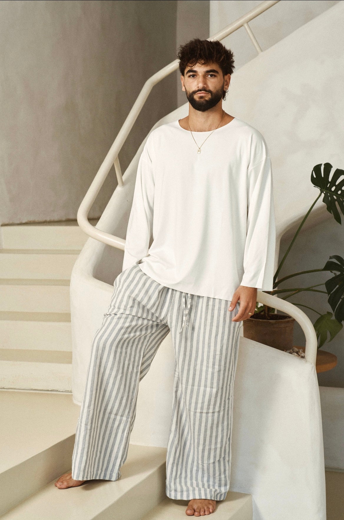 דוגמן בחולצת BASIC לבנה ובמכנסי פסים בגוונים בהירים