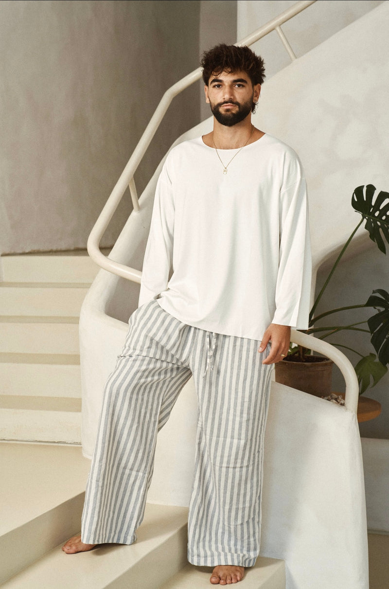 דוגמן בחולצת BASIC לבנה ובמכנסי פסים בגוונים בהירים