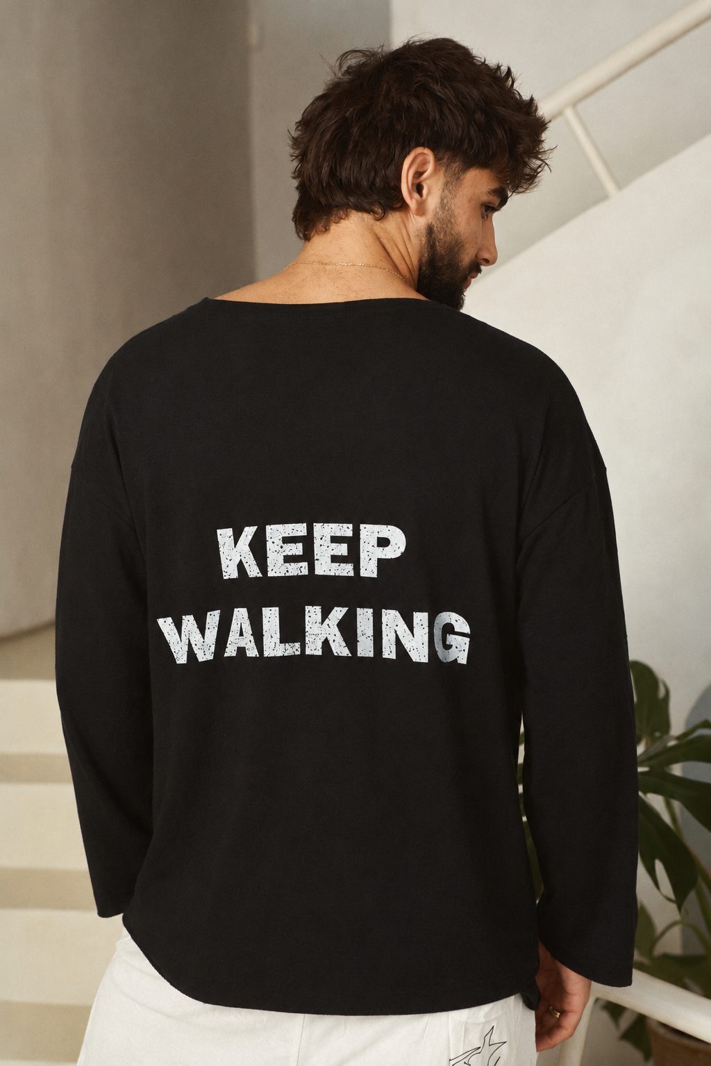 דוגמן מציג את גב חולצת KEEP WALKING השחורה