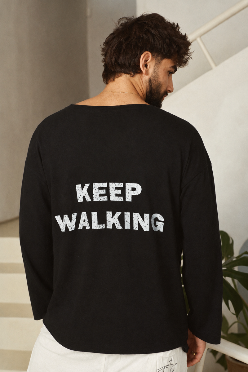 דוגמן מציג את גב חולצת KEEP WALKING השחורה